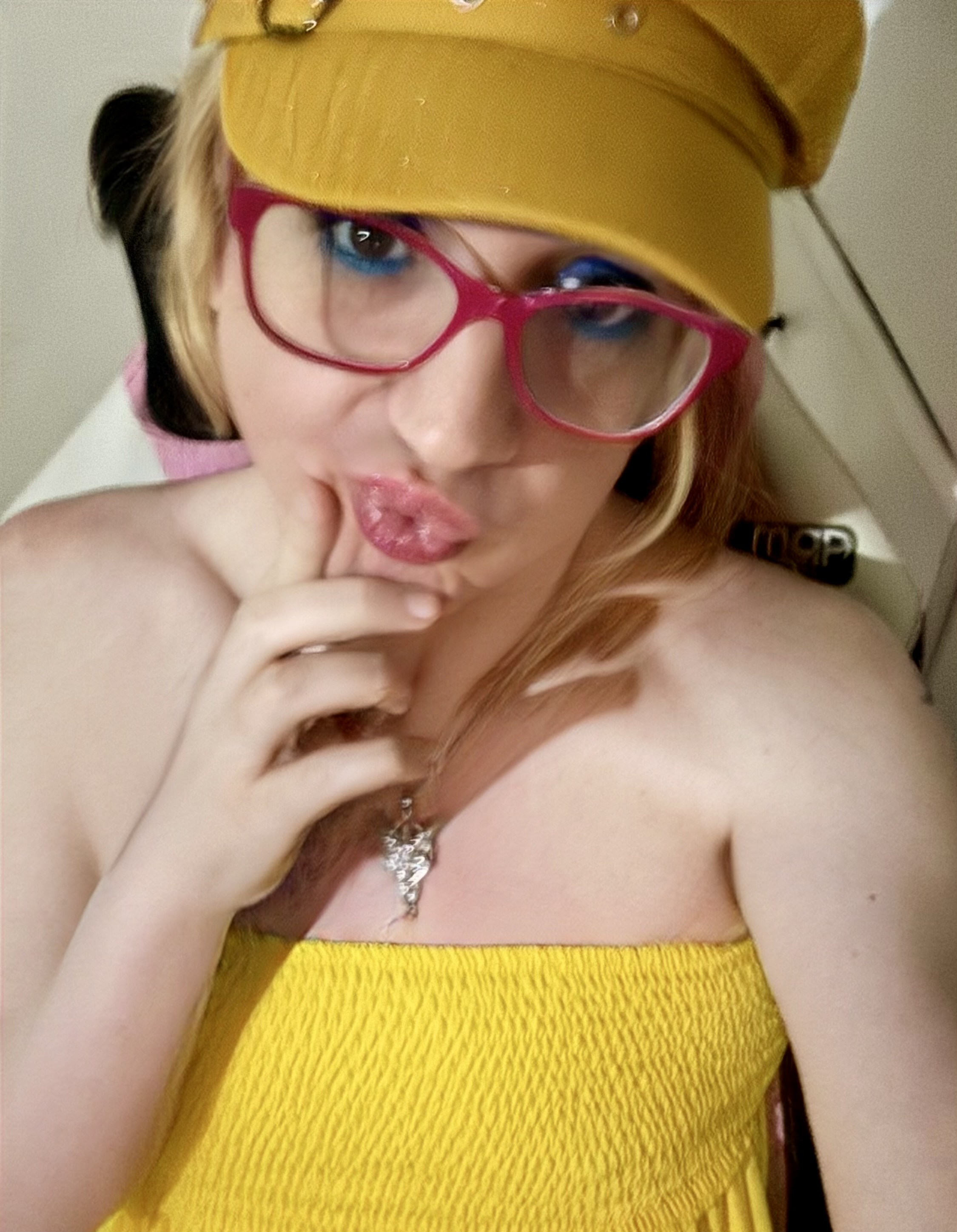 Catie wearing pink glasses and vivid blue eye makeup